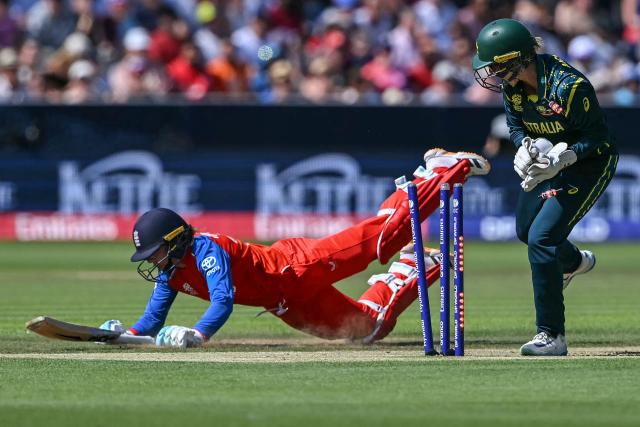 England's Danni Wyatt-Hodge (L) dives back safely before Australia's wicketkeeper Beth Mooney (R) manages to break the stumps, during the ICC Women's T20 cricket world cup 2026 final between Australia and England, at Lord's in London on July 5, 2026. (Photo by JUSTIN TALLIS / AFP)