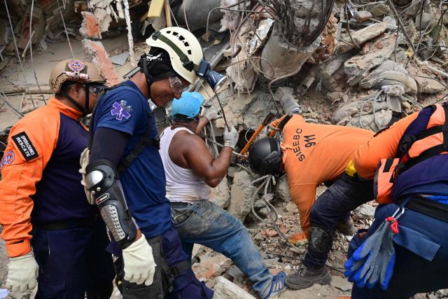 Rescue workers look for victims in Playa Grande, Catia La Mar, La Guaira State, Venezuela on July 5, 2026, following the June 24 twin earthquakes. The devastating earthquakes that struck Venezuela eleven days ago have now claimed nearly 3,000 lives, according to the latest figures released on July 4, 2026, as foreign rescue teams wind down their operations to find survivors. (Photo by MARTIN BERNETTI / AFP)