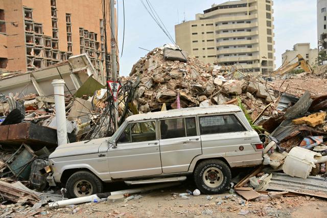 View of a car and rubble in Playa Grande, Catia La Mar, La Guaira State, Venezuela on July 5, 2026, following the June 24 twin earthquakes. The devastating earthquakes that struck Venezuela eleven days ago have now claimed nearly 3,000 lives, according to the latest figures released on July 4, 2026, as foreign rescue teams wind down their operations to find survivors. (Photo by MARTIN BERNETTI / AFP)