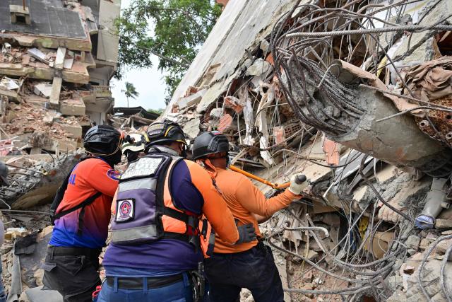Rescue workers look for victims in Playa Grande, Catia La Mar, La Guaira State, Venezuela on July 5, 2026, following the June 24 twin earthquakes. The devastating earthquakes that struck Venezuela eleven days ago have now claimed nearly 3,000 lives, according to the latest figures released on July 4, 2026, as foreign rescue teams wind down their operations to find survivors. (Photo by MARTIN BERNETTI / AFP)