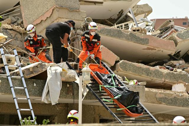 EDITORS NOTE: Graphic content / Rescue workers recover a corpse from the rubble in Playa Grande, Catia La Mar, La Guaira State, Venezuela on July 5, 2026, following the June 24 twin earthquakes. The devastating earthquakes that struck Venezuela eleven days ago have now claimed nearly 3,000 lives, according to the latest figures released on July 4, 2026, as foreign rescue teams wind down their operations to find survivors. (Photo by MARTIN BERNETTI / AFP)