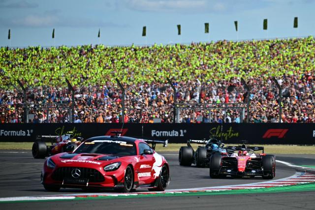 Ferrari's Monegasque driver Charles Leclerc (R), Mercedes' British driver George Russell (2R) and Ferrari's British driver Lewis Hamilton (L) tucked in behind the safety car (2L) during the Formula One British Grand Prix at the Silverstone motor racing circuit in Silverstone, central England, on July 5, 2026. (Photo by Ben STANSALL / AFP)