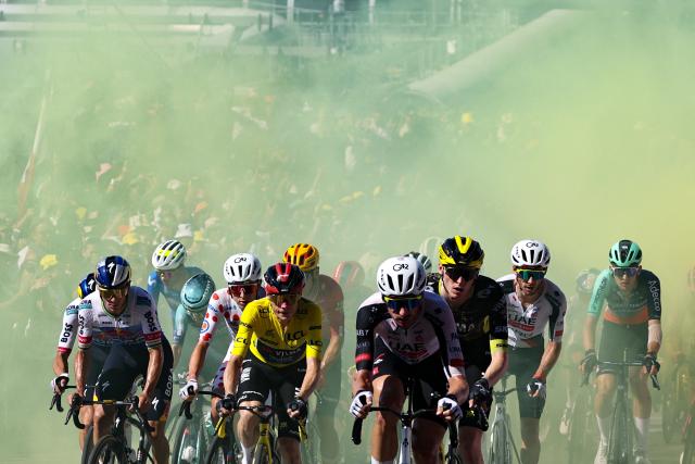 TOPSHOT - Red Bull - BORA - hansgrohe team's Belgian rider Remco Evenepoel (L), UAE Team Emirates - XRG's Slovenian rider Tadej Pogacar wearing the climber's dotted jersey (2nd L), Team Visma | Lease a Bike's Danish rider Jonas Vingegaard wearing the overall leader's yellow jersey (C), UAE Team Emirates - XRG's US rider Brandon McNulty (center R) and riders emerge from yellow smoke as they cycle in the ascent of Montjuic Palace in the final kilometers of the 2nd stage of the 113th edition of the Tour de France cycling race, 168,5 km between Tarragona and Barcelona in northeastern Spain, on July 5, 2026. (Photo by Anne-Christine POUJOULAT / AFP)