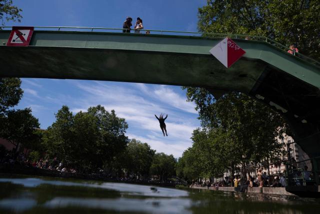 This picture shows teenagers jumping into the Canal Saint Martin in central Paris, on July 5, 2026. (Photo by Olivier MORIN / AFP)