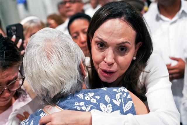 Venezuelan opposition leader Maria Corina Machado embraces a woman as she leaves after a mass at the National Basilica Santa Maria la Antigua in Panama City on July 5, 2026. (Photo by ARNULFO FRANCO / AFP)