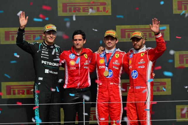 (L-R) Mercedes' British driver George Russell, Ferrari race engineer, Bryan Bozzi, Ferrari's Monegasque driver Charles Leclerc and Ferrari's British driver Lewis Hamilton pose on the podium after Leclerc wins the Formula One British Grand Prix at the Silverstone motor racing circuit in Silverstone, central England, on July 5, 2026. (Photo by Andrej ISAKOVIC / AFP)