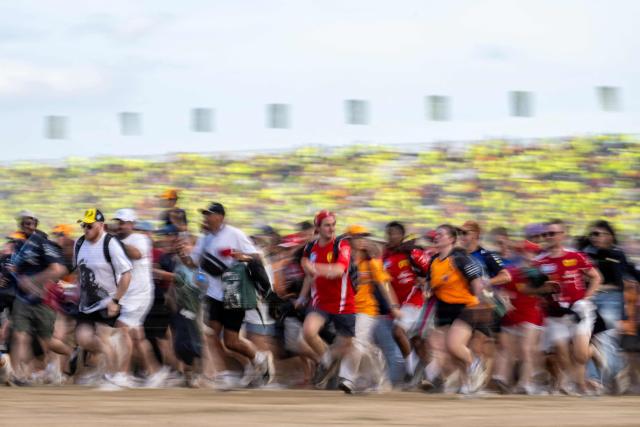 Fans run across the track following the Formula One British Grand Prix at the Silverstone motor racing circuit in Silverstone, central England, on July 5, 2026. (Photo by Ben STANSALL / AFP)