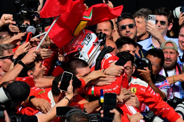 Ferrari's Monegasque driver Charles Leclerc (C) is surrounded by team members as they celebrate after he finished first to win the Formula One British Grand Prix at the Silverstone motor racing circuit in Silverstone, central England, on July 5, 2026. (Photo by Andrej ISAKOVIC / AFP)