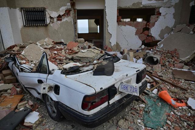 View of a car amid the rubble in Playa Grande, Catia La Mar, La Guaira State, Venezuela on July 5, 2026, following the June 24 twin earthquakes. The devastating earthquakes that struck Venezuela eleven days ago have now claimed nearly 3,000 lives, according to the latest figures released on July 4, 2026, as foreign rescue teams wind down their operations to find survivors. (Photo by MARTIN BERNETTI / AFP)