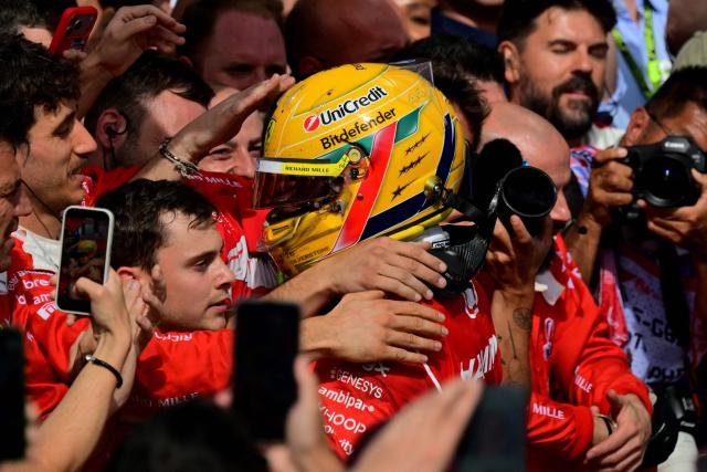 Ferrari's British driver Lewis Hamilton (C) celebrates with team members after finishing third in the Formula One British Grand Prix at the Silverstone motor racing circuit in Silverstone, central England, on July 5, 2026. (Photo by Andrej ISAKOVIC / AFP)
