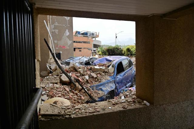 View of a car amid the rubble in Playa Grande, Catia La Mar, La Guaira State, Venezuela on July 5, 2026, following the June 24 twin earthquakes. The devastating earthquakes that struck Venezuela eleven days ago have now claimed nearly 3,000 lives, according to the latest figures released on July 4, 2026, as foreign rescue teams wind down their operations to find survivors. (Photo by MARTIN BERNETTI / AFP)