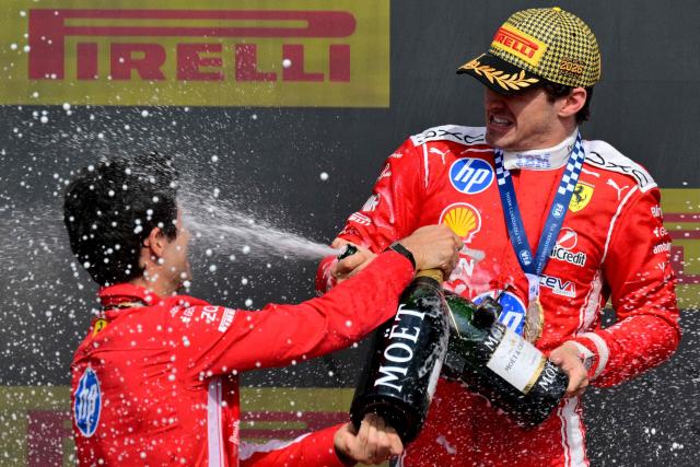 Ferrari's Monegasque driver Charles Leclerc (R) sprays champagne as he celebrates on the podium after winning the Formula One British Grand Prix at the Silverstone motor racing circuit in Silverstone, central England, on July 5, 2026. (Photo by Andrej ISAKOVIC / AFP)