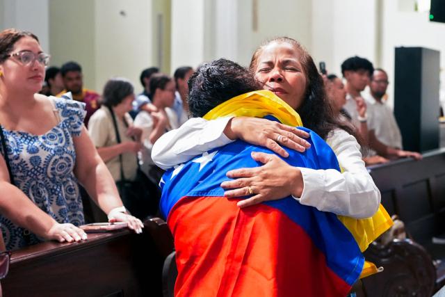 Members of the Venezuelan community in Panama embrace during a mass attended by Venezuelan opposition leader Maria Corina Machado (out of frame) at the National Basilica of Santa Maria la Antigua in Panama City on July 5, 2026. (Photo by ARNULFO FRANCO / AFP)