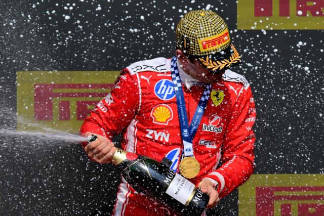 Ferrari's Monegasque driver Charles Leclerc sprays champagne as he celebrates on the podium after winning the Formula One British Grand Prix at the Silverstone motor racing circuit in Silverstone, central England, on July 5, 2026. (Photo by Andrej ISAKOVIC / AFP)