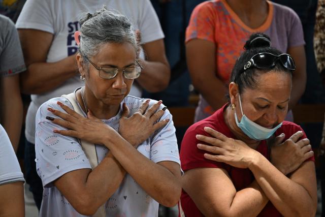 People attend a mass at the Jerusalem square in Maiquetia, Venezuela on July 5, 2026, following the June 24 twin earthquakes. The devastating earthquakes that struck Venezuela eleven days ago have now claimed nearly 3,000 lives, according to the latest figures released on July 4, 2026, as foreign rescue teams wind down their operations to find survivors. (Photo by Raul ARBOLEDA / AFP)