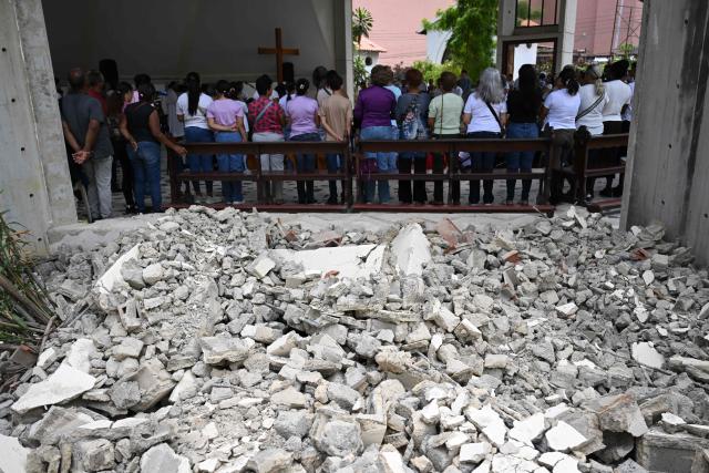 People attend a mass at the Jerusalem square in Maiquetia, Venezuela on July 5, 2026, following the June 24 twin earthquakes. The devastating earthquakes that struck Venezuela eleven days ago have now claimed nearly 3,000 lives, according to the latest figures released on July 4, 2026, as foreign rescue teams wind down their operations to find survivors. (Photo by Raul ARBOLEDA / AFP)