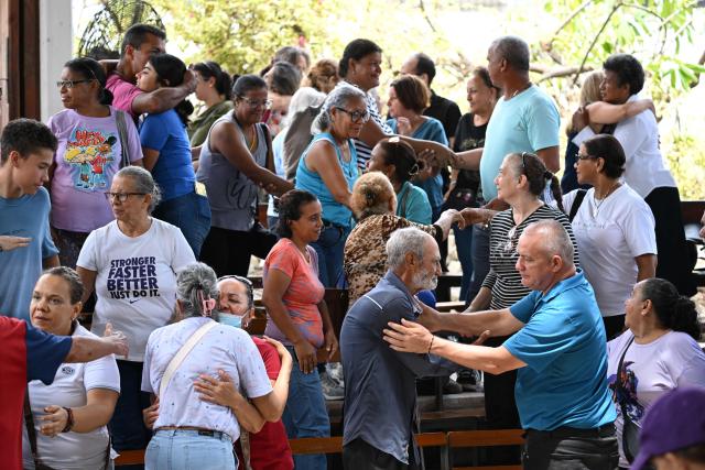 People attend a mass at the Jerusalem square in Maiquetia, Venezuela on July 5, 2026, following the June 24 twin earthquakes. The devastating earthquakes that struck Venezuela eleven days ago have now claimed nearly 3,000 lives, according to the latest figures released on July 4, 2026, as foreign rescue teams wind down their operations to find survivors. (Photo by Raul ARBOLEDA / AFP)