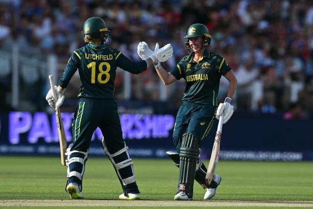 Australia's Phoebe Litchfield (L) and Australia's Beth Mooney (R) celebrate their 100 partnership during the ICC Women's T20 cricket world cup 2026 final between Australia and England, at Lord's in London on July 5, 2026. (Photo by JUSTIN TALLIS / AFP)