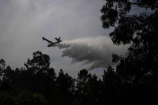 A Spanish Canadair plane drops water over a wildfire near the village of Daires, central Portugal, on July 05, 2026. (Photo by MIGUEL RIOPA / AFP)