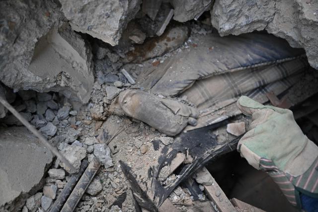 EDITORS NOTE: Graphic content / A rescue worker points at the corpse of a child beneath the rubble in Macuto, Vargas state, Venezuela, on July 5, 2026, following the June 24 twin earthquakes. The devastating earthquakes that struck Venezuela eleven days ago have now claimed nearly 3,000 lives, according to the latest figures released on July 4, 2026, as foreign rescue teams wind down their operations to find survivors. (Photo by Raul ARBOLEDA / AFP)