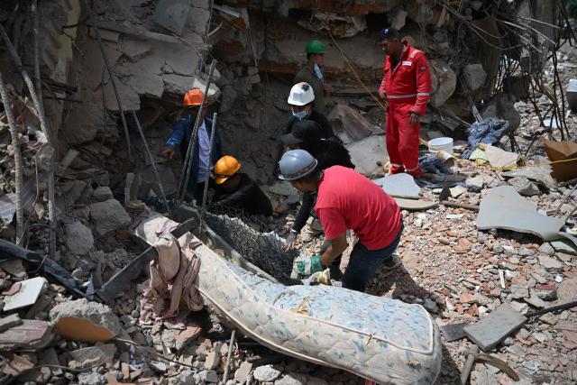 EDITORS NOTE: Graphic content / Rescue workers find corpses amid the rubble in Macuto, Vargas state, Venezuela, on July 5, 2026, following the June 24 twin earthquakes. The devastating earthquakes that struck Venezuela eleven days ago have now claimed nearly 3,000 lives, according to the latest figures released on July 4, 2026, as foreign rescue teams wind down their operations to find survivors. (Photo by Raul ARBOLEDA / AFP)