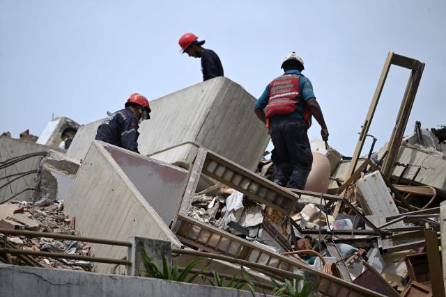 EDITORS NOTE: Graphic content / Rescue workers look for victims amid the rubble in Macuto, Vargas state, Venezuela, on July 5, 2026, following the June 24 twin earthquakes. The devastating earthquakes that struck Venezuela eleven days ago have now claimed nearly 3,000 lives, according to the latest figures released on July 4, 2026, as foreign rescue teams wind down their operations to find survivors. (Photo by Raul ARBOLEDA / AFP)