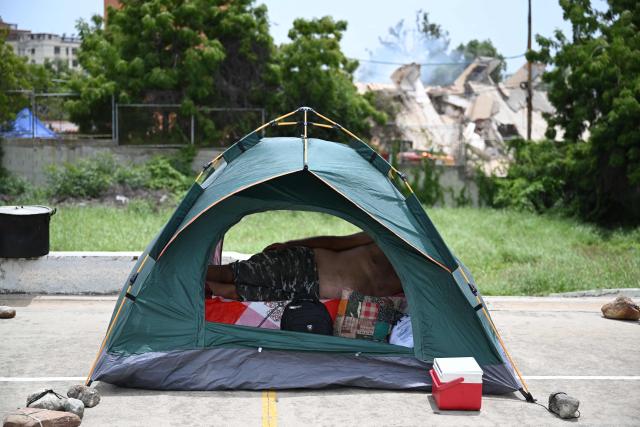 EDITORS NOTE: Graphic content / A man remains snside a tent at a makeshift camp in Macuto, Vargas state, Venezuela, on July 5, 2026, following the June 24 twin earthquakes. The devastating earthquakes that struck Venezuela eleven days ago have now claimed nearly 3,000 lives, according to the latest figures released on July 4, 2026, as foreign rescue teams wind down their operations to find survivors. (Photo by Raul ARBOLEDA / AFP)