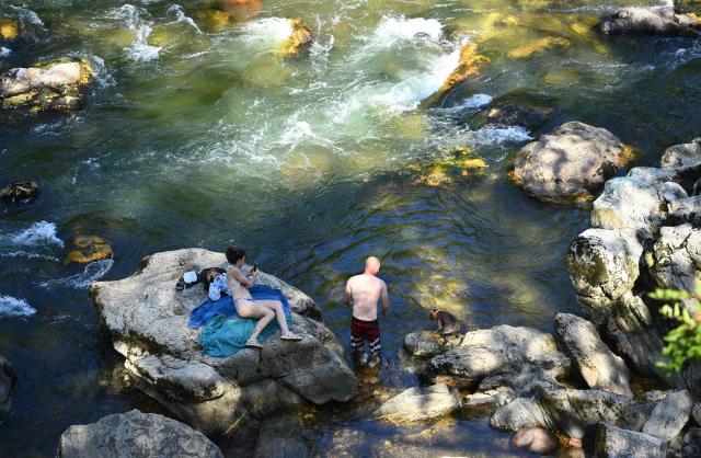 Local residents bathe in the Nive river as a heatwave sweeps across southwestern France in Itxassou, south-western France, on July 04, 2026. (Photo by Gaizka IROZ / AFP)
