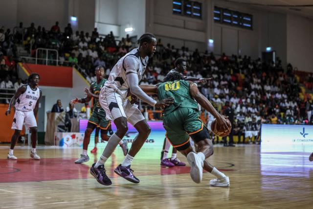 Cameroon's #8 Samir Gbetkom (R) and South Soudan's #20 Jackson Makoi (L) fight for the ball during a basketball match game between Cameron vs South Soudan played on the third day of the African qualifying for the 2027 Men's Basketball World Cup in Qatar, in Douala on July 5, 2026. (Photo by Daniel BELOUMOU OLOMO / AFP)