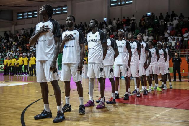 South Soudan's national basketball team reacts during the national anthem before a basketball match game between Cameron vs South Soudan played on the third day of the African qualifying for the 2027 Men's Basketball World Cup in Qatar, in Douala on July 5, 2026. (Photo by Daniel BELOUMOU OLOMO / AFP)