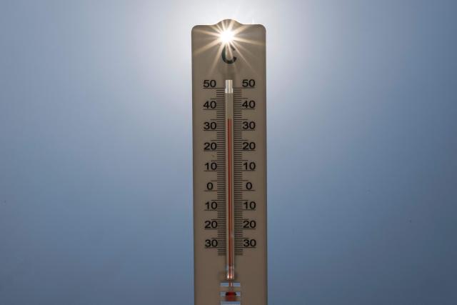 (FILES) This photograph shows sun rays shining through a handheld house thermometer reading 35 degrees Celsius, in Montreuil on the afternoon of August 14, 2025, amid a heatwave in Europe. France faces another spell of intense heat, a third spell of intense heat in just over a month, stepping up heat alerts on July 5, 2026 with temperatures beginning to rise again with forecasters predicting it could last until the following weekend. (Photo by Martin LELIEVRE / AFP)