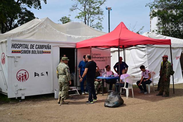 Soldiers and health workers remain at a field hospital and refuge set up in a golf course in Caraballeda, La Guaira state, Venezuela, on July 5, 2026, following the June 24 twin earthquakes. The devastating earthquakes that struck Venezuela eleven days ago have now claimed nearly 3,000 lives, according to the latest figures released on July 4, 2026, as foreign rescue teams wind down their operations to find survivors. (Photo by MARTIN BERNETTI / AFP)