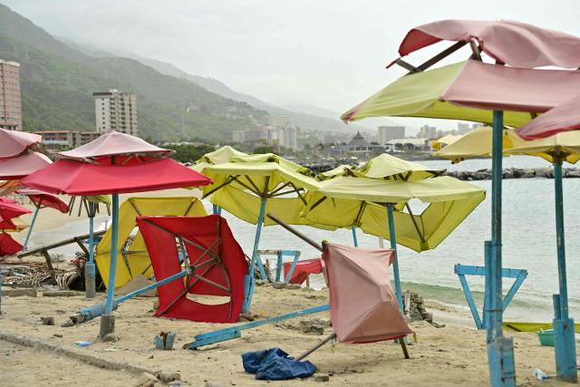 View of umbrellas at the beach of Caraballeda, La Guaira state, Venezuela, on July 5, 2026, following the June 24 twin earthquakes. The devastating earthquakes that struck Venezuela eleven days ago have now claimed nearly 3,000 lives, according to the latest figures released on July 4, 2026, as foreign rescue teams wind down their operations to find survivors. (Photo by MARTIN BERNETTI / AFP)