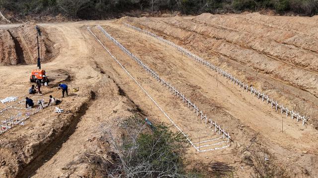 This aerial view shows plots containing the graves of unidentified individuals, victims of the twin earthquakes, at La Esperanza Cemetery in Catia La Mar, La Guaira state, northeast of Caracas, on July 5, 2026. Venezuela's devastating twin earthquakes killed nearly 3,000, updated official figures showed on July 4, as international rescue teams began winding down search operations for survivors in the rubble of the disaster. (Photo by Miguel MEDINA / AFP)