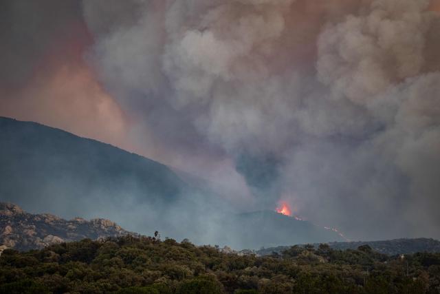 This photograph shows a cloud of smoke from a wildfire burning in the Aspres region seen from Montalba-le-Chateau, in the Pyrenees-Orientales department, southern France on July 5, 2026. A wildfire broke out on July 4 at around 19h30 (1730 GMT) in a hard-to-reach massif near Trevillach, in the Pyrenees-Orientales department of southern France and spread rapidly overnight. More than 10,000 residents are currently being evacuated as the wildfire spreads rapidly, having burned around 2,000 hectares. (Photo by Jc Milhet / AFP)