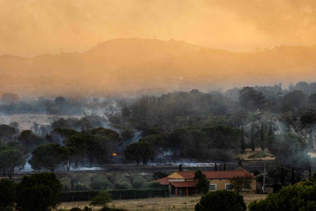 This photograph shows land smouldering after a wildfire passed through on the outskirts of Montalba-le-Chateau, in the Pyrenees-Orientales department, southern France on July 5, 2026. A wildfire broke out on July 4 at around 19h30 (1730 GMT) in a hard-to-reach massif near Trevillach, in the Pyrenees-Orientales department of southern France and spread rapidly overnight. More than 10,000 residents are currently being evacuated as the wildfire spreads rapidly, having burned around 2,000 hectares. (Photo by Jc Milhet / AFP)