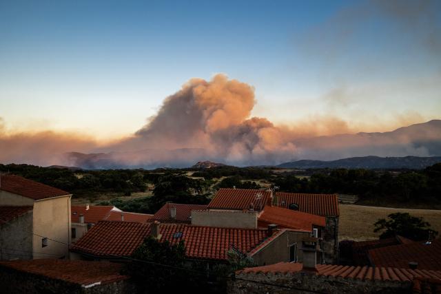 This photograph shows a cloud of smoke from a wildfire burning in the Aspres region seen from Montalba-le-Chateau, in the Pyrenees-Orientales department, southern France on July 5, 2026. A wildfire broke out on July 4 at around 19h30 (1730 GMT) in a hard-to-reach massif near Trevillach, in the Pyrenees-Orientales department of southern France and spread rapidly overnight. More than 10,000 residents are currently being evacuated as the wildfire spreads rapidly, having burned around 2,000 hectares. (Photo by Jc Milhet / AFP)