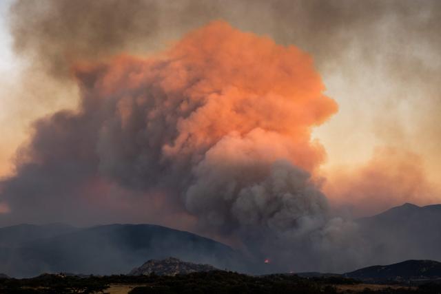 This photograph shows a cloud of smoke from a wildfire burning in the Aspres region seen from Montalba-le-Chateau, in the Pyrenees-Orientales department, southern France on July 5, 2026. A wildfire broke out on July 4 at around 19h30 (1730 GMT) in a hard-to-reach massif near Trevillach, in the Pyrenees-Orientales department of southern France and spread rapidly overnight. More than 10,000 residents are currently being evacuated as the wildfire spreads rapidly, having burned around 2,000 hectares. (Photo by Jc Milhet / AFP)