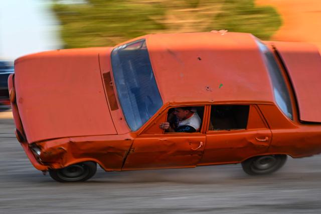 Stuntman Dawson Cancy drives a car balanced on two wheels during the opening day of the summer season of the Show Mecanique Team in Serignan, southern France on July 5, 2026. (Photo by Gabriel BOUYS / AFP)