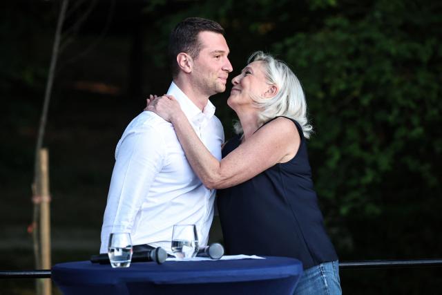 French far-right party Rassemblement National (RN) president Jordan Bardella (L) and President of Rassemblement National parliamentary group Marine Le Pen embrace as they attend a RN party event "La fete champetre" in Lievin, northern France on July 4, 2026. (Photo by SIMON WOHLFAHRT / AFP)