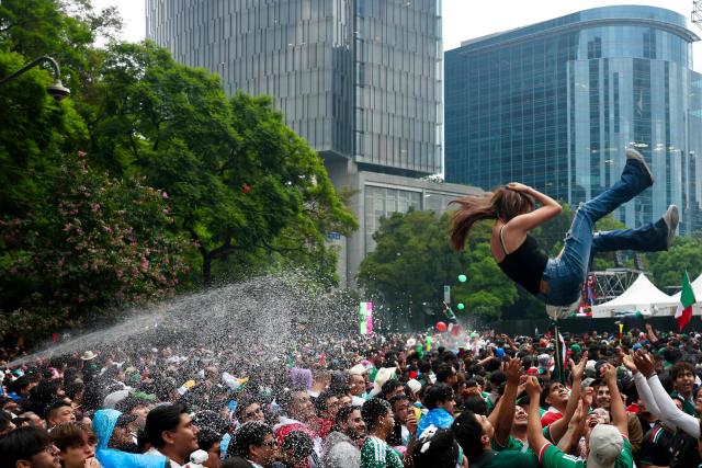 A Mexican football fan is tossed into the air by others as fans gather at the Angel of Independence to watch the 2026 FIFA World Cup Round of 16 football match between Mexico and England in Mexico City on July 5, 2026. (Photo by Claudia Rosel / AFP)