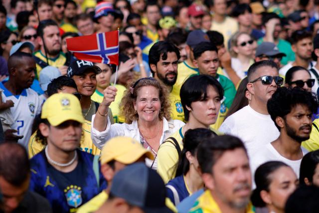 A Norway's fan waves her country's flag surrounded by Brazilian fans while watching the 2026 World Cup round of 16 football match between Brazil and Norway at a watch party in Hudson Yards Backyard in New York City on July 5, 2026. (Photo by Leonardo MUNOZ / AFP)