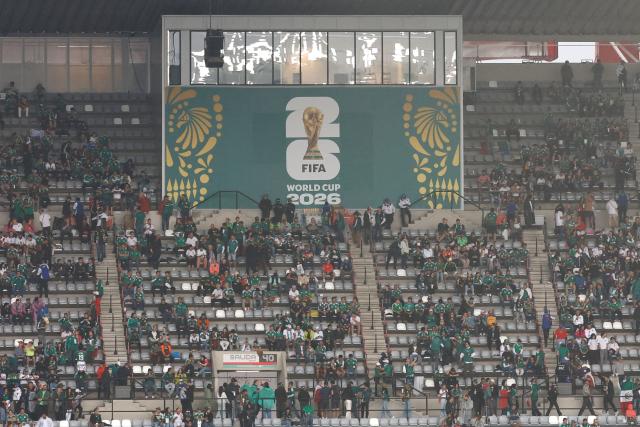 Mexican fans take shelter from the rain ahead of the 2026 World Cup round of 16 football match between Mexico and England at the Mexico City Stadium in Mexico City on July 5, 2026.  (Photo by Ulises RUIZ / AFP)