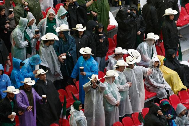 Mexican fans wear raincoats and hats ahead of the 2026 World Cup round of 16 football match between Mexico and England at the Mexico City Stadium in Mexico City on July 5, 2026.  (Photo by Ulises RUIZ / AFP)