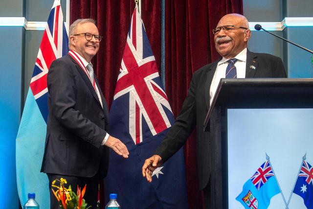 Australian Prime Minister Anthony Albanese (L) and Fiji's Prime Minister Sitiveni Rabuka (R) shake hands after a joint press conference at the Grand Pacific Hotel in Suva on July 6, 2026. Australia signed a new defence alliance with Fiji on July 6, bolstering ties with its South Pacific island neighbor as it seeks to outmanoeuvre China in the region. (Photo by Leon LORD / AFP)