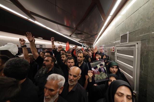 People walk out of a train station as they arrvie for the funeral procession of Iran's slain Supreme Leader Ali Khamenei in Tehran July 6, 2026. Massive crowds are expected on July 6 for the funeral procession of late Iranian supreme leader Ali Khamenei in Tehran, with authorities hoping to avoid a repeat of the chaos that accompanied his predecessor's funeral. (Photo by ATTA KENARE / AFP) / 