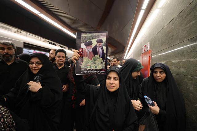 People walk out of a train station as they arrvie for the funeral procession of Iran's slain Supreme Leader Ali Khamenei in Tehran July 6, 2026. Massive crowds are expected on July 6 for the funeral procession of late Iranian supreme leader Ali Khamenei in Tehran, with authorities hoping to avoid a repeat of the chaos that accompanied his predecessor's funeral. (Photo by ATTA KENARE / AFP) / 