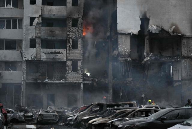 This photograph shows burned cars parked outside a residential building following a Russian missile strike on the Ukrainian capital of Kyiv on July 6, 2026, amid the Russian invasion in Ukraine. Russia struck Ukraine's Kyiv region with ballistic missiles on July 6, killing at least eight people and wounding dozens, authorities said, on the eve of a NATO summit in Turkey. (Photo by Genya SAVILOV / AFP)