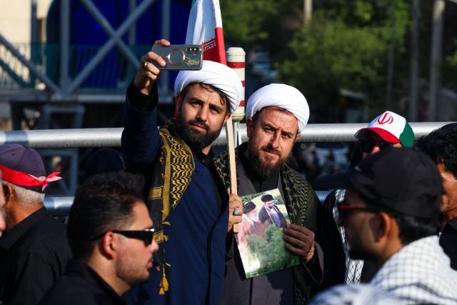Men take a selfie as they wait for the funeral procession of Iran's slain Supreme Leader Ali Khamenei in Tehran July 6, 2026. Massive crowds are expected on July 6 for the funeral procession of late Iranian supreme leader Ali Khamenei in Tehran, with authorities hoping to avoid a repeat of the chaos that accompanied his predecessor's funeral. (Photo by ATTA KENARE / AFP) / 