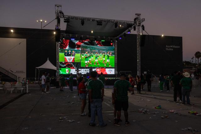 As the crowd leaves some Mexico fans watch their team acknowledge their supporters after they lost their 2026 World Cup round of 16 football match against England during a watch party at Ace Mission Studios, in Los Angeles, California, on July 5, 2026. (Photo by ETIENNE LAURENT / AFP)